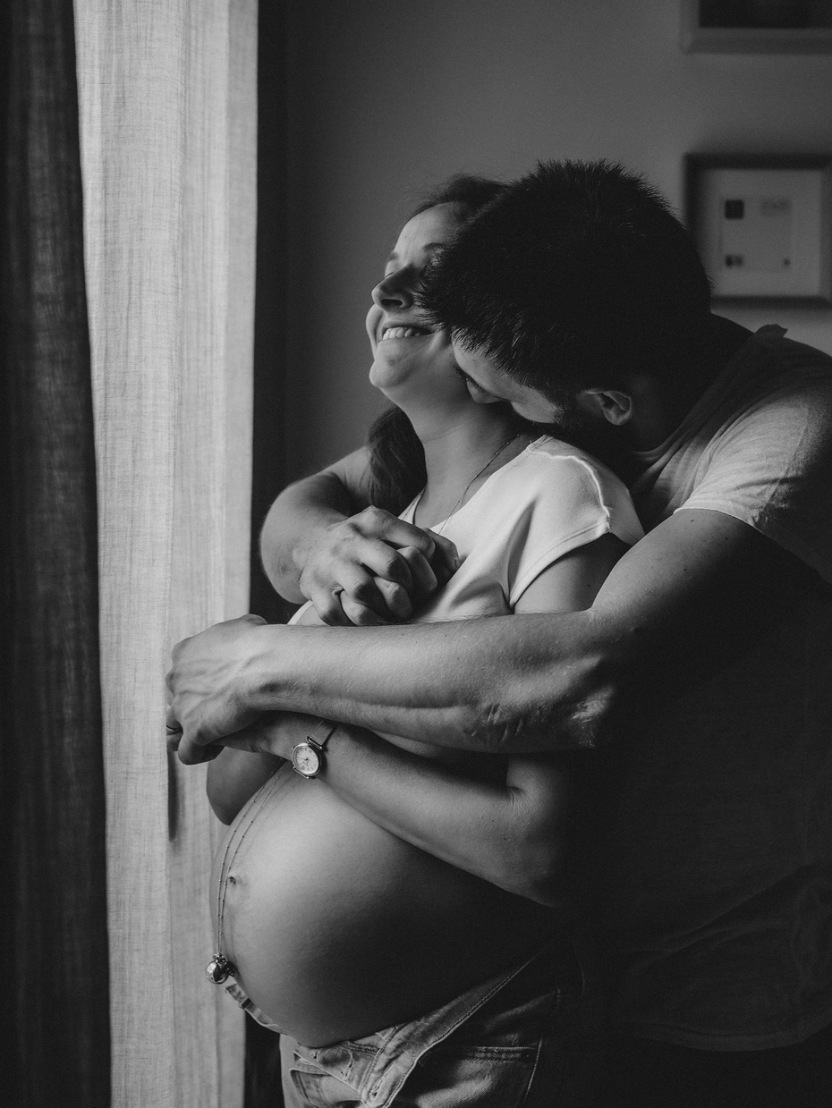 Photo de grossesse, maternité, femme enceinte. Couple avec bisou dans le cou.