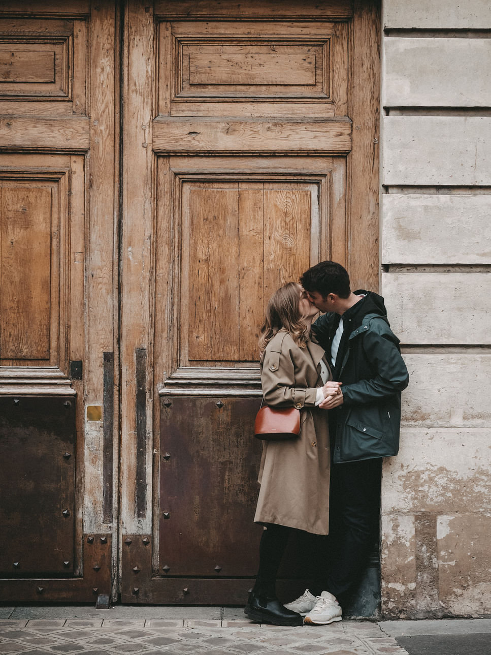 Photo d'amoureux, couple, qui s'embrassent devant une grande porte à Paris.